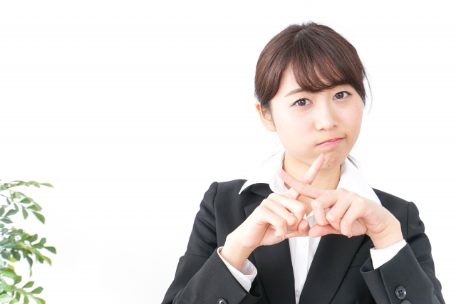 指でNGマークを作る、転職活動中の女性調理師のイメージ